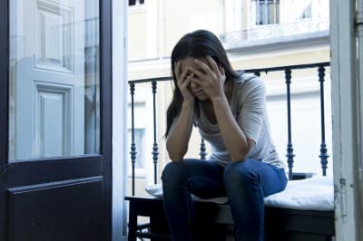 young sad and desperate Latin woman sitting at home balcony looking destroyed and depressed suffering depression feeling lonely unhappy and hopeless in mental health and crisis concept